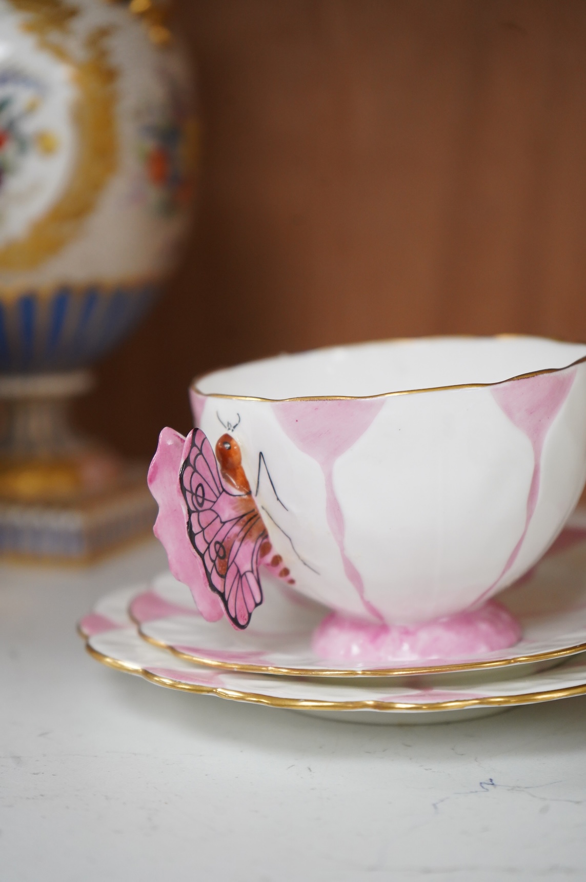 Two Aynsley trios with butterfly handles and one extra saucer, numbered 785788